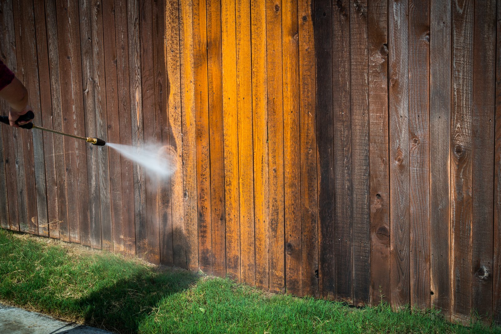 Power washing wooden fence to restore it to new